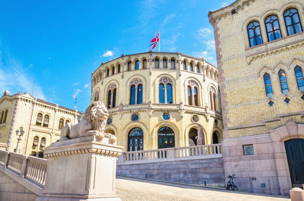 Historic parliament building with lion statue and flag