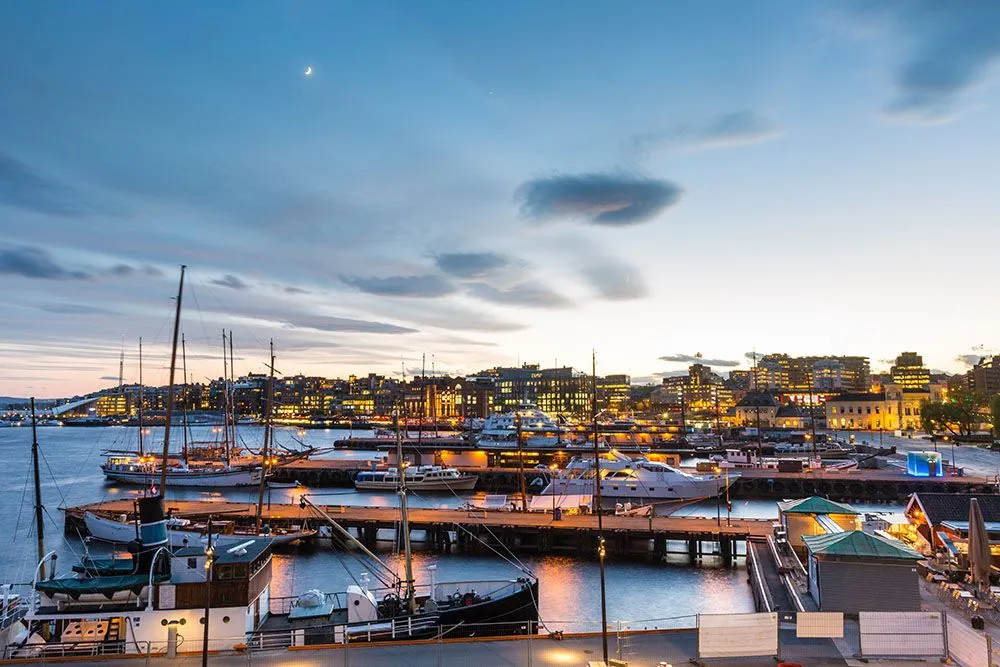 Evening view of city harbour with boats and lights