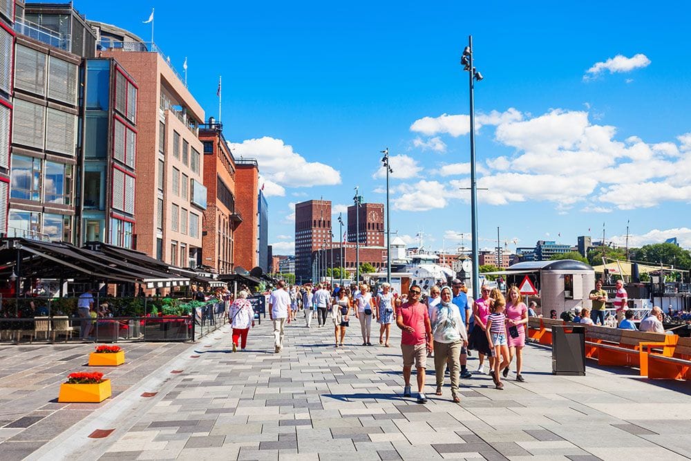 People walking along a sunny waterfront promenade