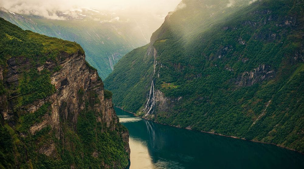 Scenic fjord with steep cliffs and waterfall