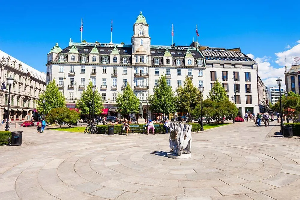 People relaxing in a city square with historic buildings